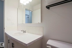 Bathroom vanity with an integrated sink, chrome faucet, and tiled backsplash - 