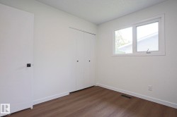 Room featuring wood-finish flooring, a double-pane window, and white trim - 