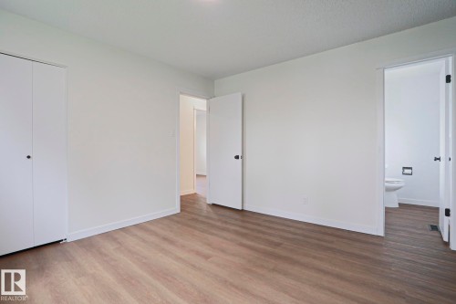 Interior room featuring wood-finish flooring, white walls, and a white bi-fold closet - 10 Murray Crescent, St. Albert, AB 