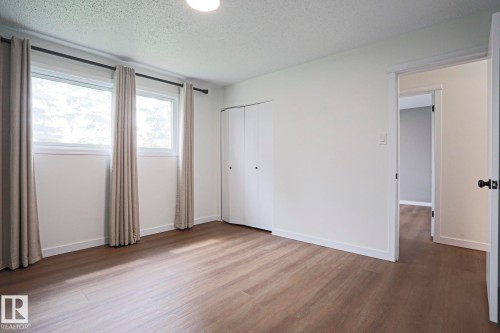 Room featuring light wood-finish flooring, white walls, and a textured ceiling - 10 Murray Crescent, St. Albert, AB 