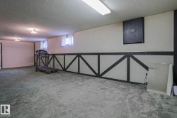 Spacious carpeted room featuring a drop ceiling with recessed lighting and a fluorescent light fixture - 