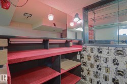 Built-in bar featuring a red carpeted countertop, open shelving, and a mirrored back wall with integrated glass shelving - 