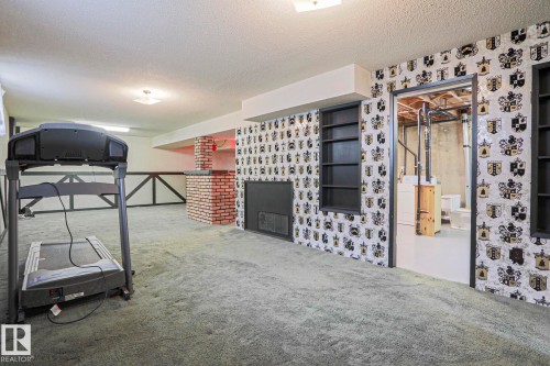 Finished lower level featuring wall-to-wall carpeting and a decorative fireplace - 10 Murray Crescent, St. Albert, AB 