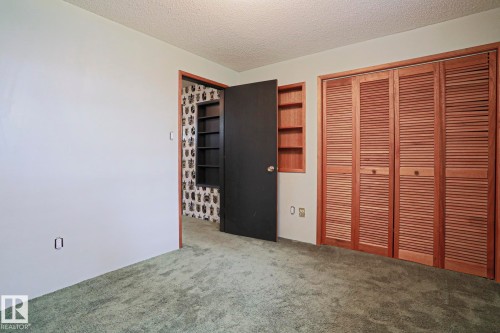 Neutral wall tones, green textured carpeting, and natural wood louvered bifold closet doors - 10 Murray Crescent, St. Albert, AB 