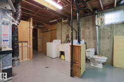 Unfinished basement featuring concrete foundation walls and exposed ceiling joists - 