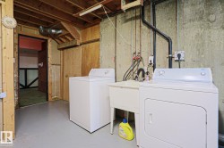 Dedicated utility area featuring a sink, exposed piping, and concrete walls - 