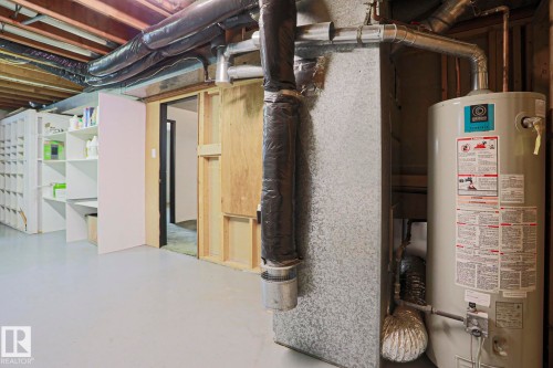 Utility area featuring a water heater and exposed overhead ductwork - 10 Murray Crescent, St. Albert, AB 
