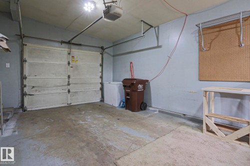 Garage space with a single overhead door, concrete flooring, and an exposed ceiling - 10 Murray Crescent, St. Albert, AB 