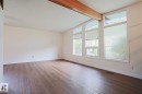 Room featuring wood-finish flooring, white walls, and a wood beam accent - 10 Murray Crescent, St. Albert, AB 