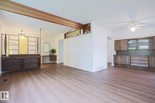Spacious interior with wood-finish flooring, exposed ceiling beam, and a decorative room divider - 10 Murray Crescent, St. Albert, AB 