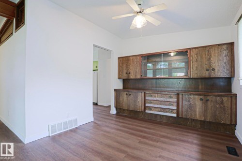 Built-in cabinetry with glass-front uppers and varied drawer fronts, wood-finish flooring, and a ceiling fan with integrated lighting - 10 Murray Crescent, St. Albert, AB 