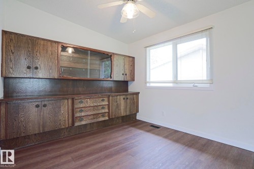 Built-in wood-finish cabinetry featuring glass-front display sections, multiple drawers, and contrasting hardware - 10 Murray Crescent, St. Albert, AB 