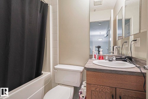 White bathtub with white tiled surround - 119 309 Clareview Station Drive, Edmonton, AB 