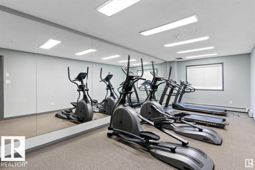 Fitness area with wall-to-wall mirrors, textured carpet flooring, and recessed rectangular lighting - 119 309 Clareview Station Drive, Edmonton, AB 