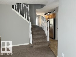 Carpeted staircase with white balusters and handrail - 