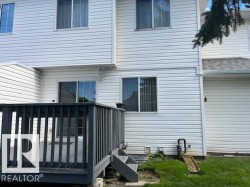 Spacious wood deck with dark-stained railing, offering direct access to the interior via a sliding glass door - 