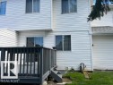 Spacious wood deck with dark-stained railing, offering direct access to the interior via a sliding glass door - 16-1033 Youville Dr. West Nw, Edmonton, AB  - Outdoor With Exterior 
