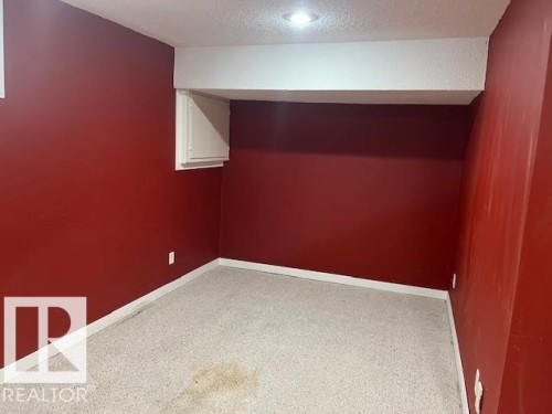 Recessed lighting illuminates a space featuring red walls, white trim, and light-colored carpeting - 16-1033 Youville Dr. West Nw, Edmonton, AB - Indoor Photo Showing Other Room