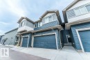 Townhouse exterior featuring dual-tone horizontal siding, prominent dormer windows, attached garage, private front entry, and concrete driveway - 37 603 Orchards Boulevard, Edmonton, AB  - Outdoor 