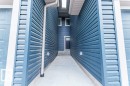 Entryway with blue horizontal siding, concrete walkway, and white rain gutters - 37 603 Orchards Boulevard, Edmonton, AB  - Outdoor 