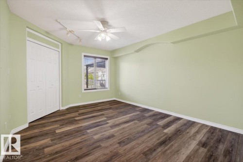 Spacious room with wood-finish flooring, a window with blinds, and a ceiling fan with integrated lighting - 946 Jordan Crescent, Edmonton, AB 