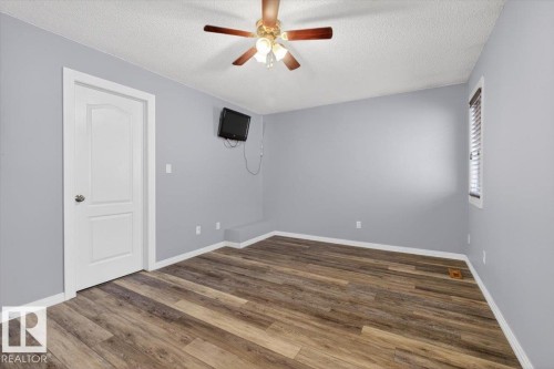 Bedroom featuring wood-finish flooring, light grey walls, white trim, and a ceiling fan - 946 Jordan Crescent, Edmonton, AB 