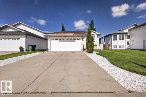 Front exterior featuring an attached two-car garage, concrete driveway, and white siding - 946 Jordan Crescent, Edmonton, AB 