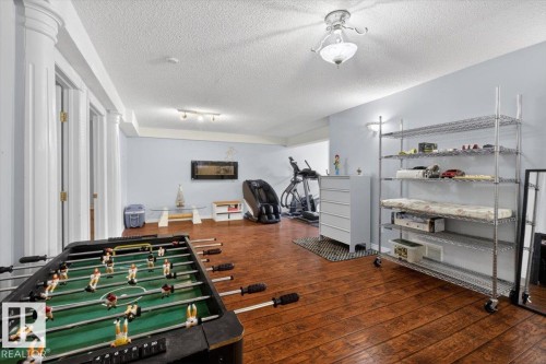 Finished basement space featuring wood-finish flooring and light blue wall tones - 946 Jordan Crescent, Edmonton, AB 