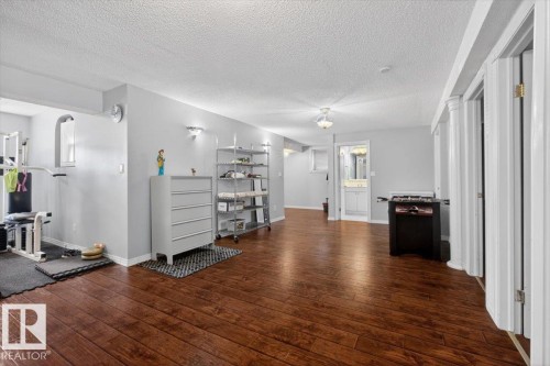 Spacious lower level featuring rich wood-finish flooring, recessed lighting, and light gray wall finishes - 946 Jordan Crescent, Edmonton, AB 