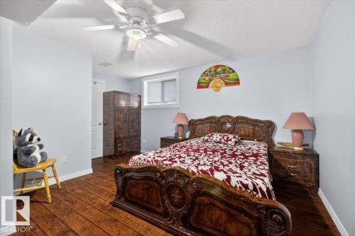 Spacious room featuring wood-finish flooring, light blue walls, and a white textured ceiling - 946 Jordan Crescent, Edmonton, AB 