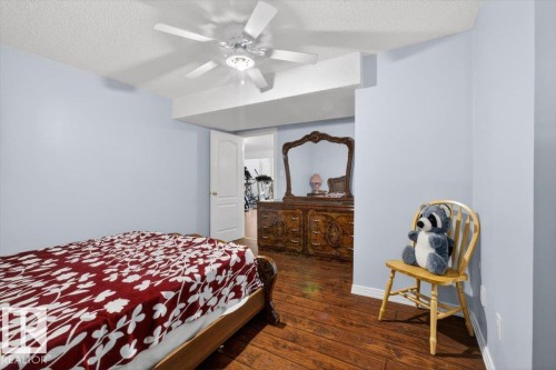 Spacious room with light blue walls, wood-finish flooring, and a ceiling fan with integrated lighting - 946 Jordan Crescent, Edmonton, AB 