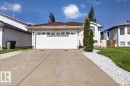 Front exterior featuring a two-car garage with a panel door, a concrete driveway, and a decorative white stone pathway - 946 Jordan Crescent, Edmonton, AB 