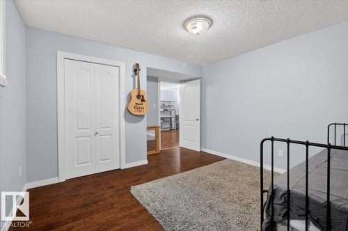 Interior room featuring wood-finish flooring, light blue wall paint, and white trim - 946 Jordan Crescent, Edmonton, AB 