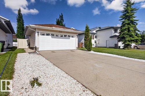 Detached single-family residence featuring a two-car garage with decorative windows, a concrete driveway, and white gravel landscaping - 946 Jordan Crescent, Edmonton, AB 