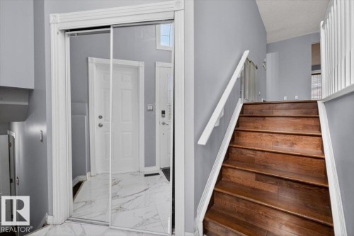 Entryway featuring a mirrored closet, white trim, and light gray walls - 946 Jordan Crescent, Edmonton, AB 