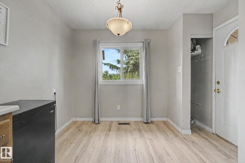 Bright interior space featuring wood-finish flooring, a central window with white trim, and light gray wall finishes - 45 2020 105 Street, Edmonton, AB 