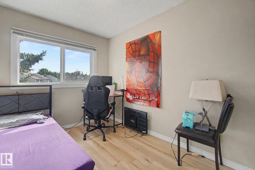 Room featuring a wide window, wood-finish flooring, and neutral wall tones - 45 2020 105 Street, Edmonton, AB 