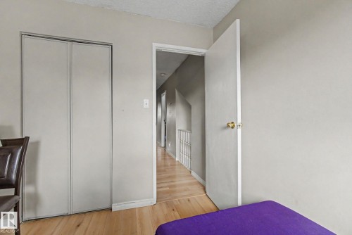 Interior room featuring wood-finish flooring, light gray walls, and a white bi-fold closet - 45 2020 105 Street, Edmonton, AB 