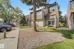 Contemporary townhome exterior featuring multi-toned siding, a distinct roofline, a prominent front entrance with large glass panels, and a concrete pathway - 