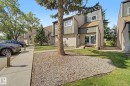 Contemporary townhome exterior featuring multi-toned siding, a distinct roofline, a prominent front entrance with large glass panels, and a concrete pathway - 45 2020 105 Street, Edmonton, AB 