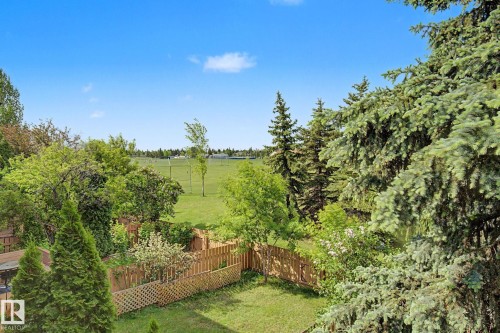 Expansive backyard featuring a manicured lawn, established landscaping, and a wooden fence - 45 2020 105 Street, Edmonton, AB 