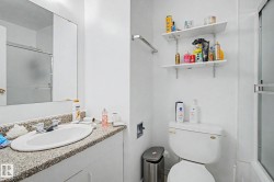 Bathroom featuring a white vanity with a speckled countertop, a built-in sink, and a chrome faucet - 
