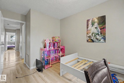 Neutral wall paint, wood-finish flooring, white baseboards, and a paneled ceiling with a subtle texture - 45 2020 105 Street, Edmonton, AB 