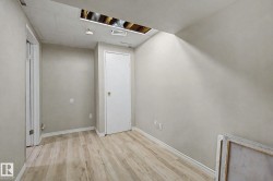 Room featuring wood-finish flooring, light gray painted walls, and white baseboards - 