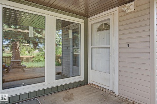 Front entry featuring a white door with an arched transom, a storm door, and horizontal siding - 45 2020 105 Street, Edmonton, AB 