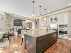 Expansive kitchen island featuring a light-toned countertop and pendant lighting - 