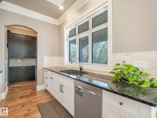 Kitchen featuring white cabinetry, dark stone countertops, and stainless steel sink - 2807 Wheaton Drive, Edmonton, AB 