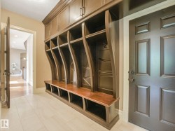 Custom built-in hall tree with upper cabinetry, open cubbies, and a seating bench - 