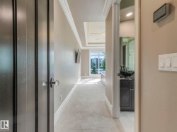 Hallway featuring crown molding, baseboards, and neutral wall tones - 