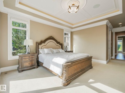 Bedroom featuring a coffered ceiling with a central medallion light fixture and recessed lighting, crown molding, and large windows - 2807 Wheaton Drive, Edmonton, AB 